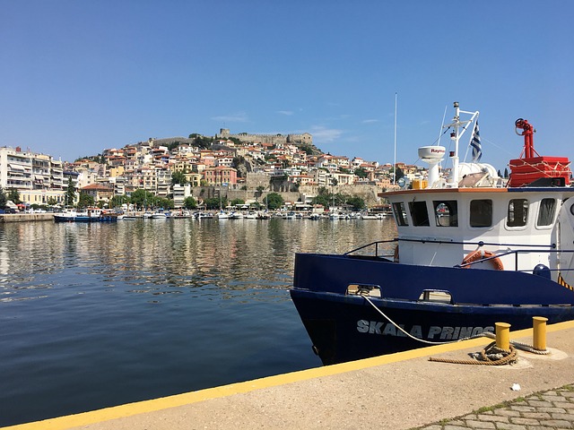 Sailing in Kavala Greece - panoramic view of the harbor with traditional boats and historic castle